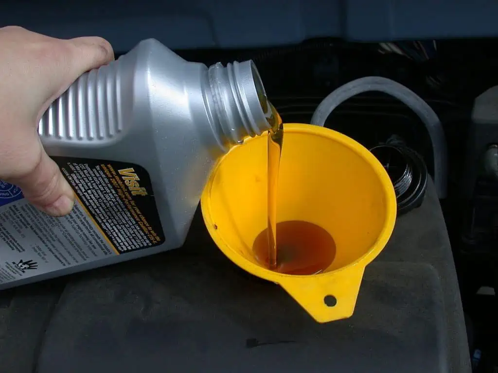 5. Using a funnel to assist with a motor oil refill 1