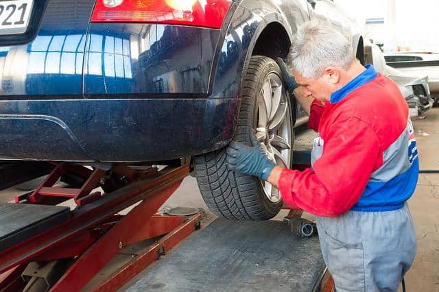 9. Inspecting car tire in garage